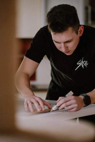 Šarūnas preparing artwork by hand at his workbench